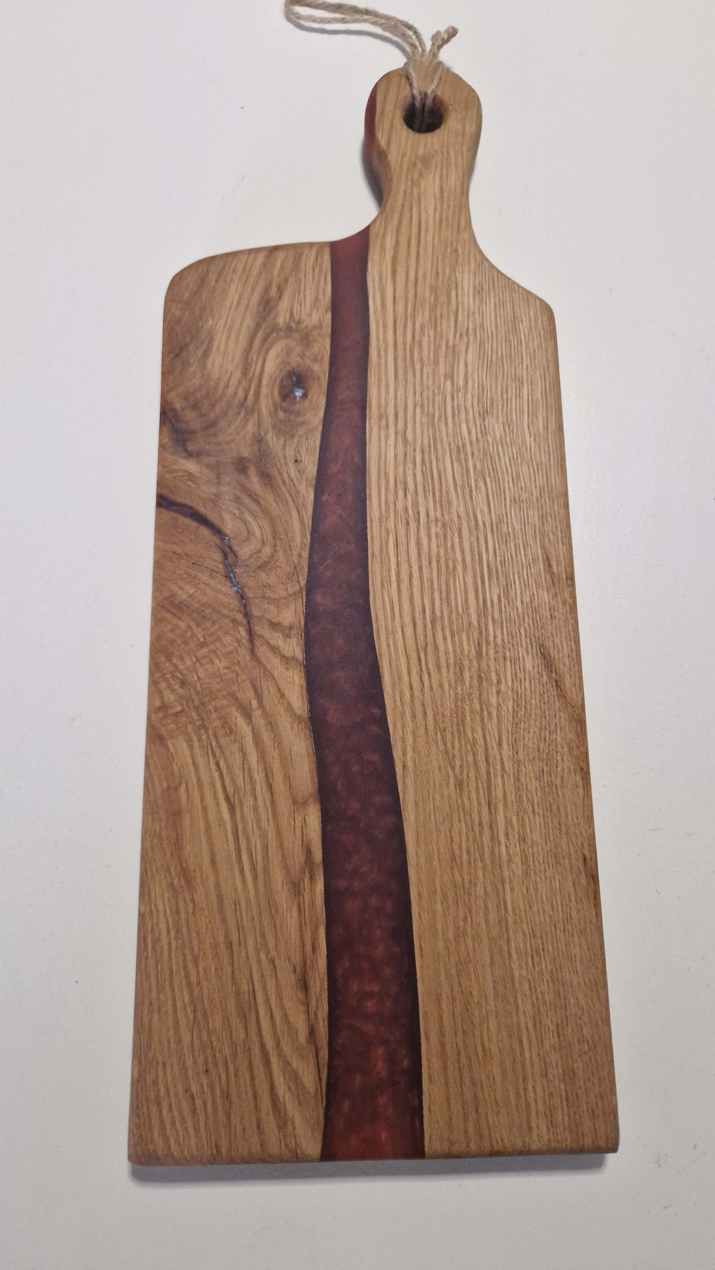Handmade charcuterie board with oak and red epoxy design.