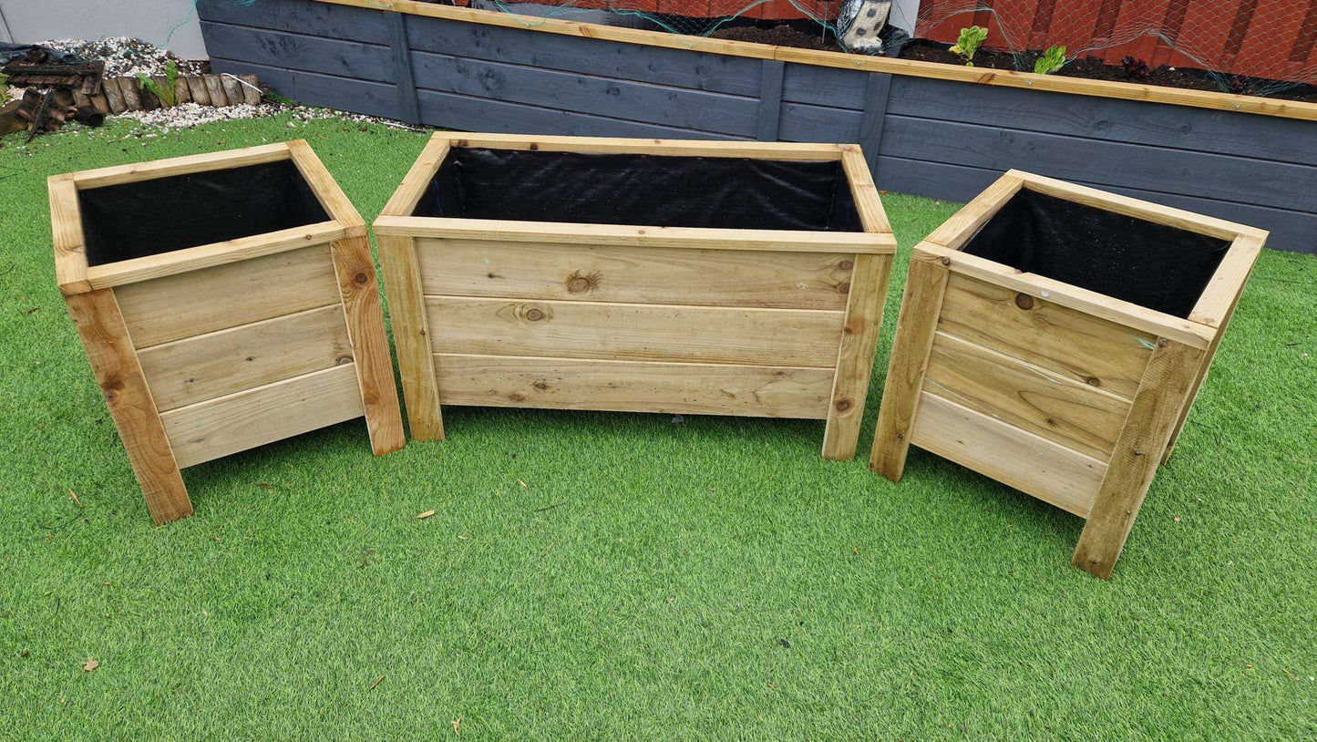 Handcrafted wooden planter set with one large and two medium matching planters on grass background.