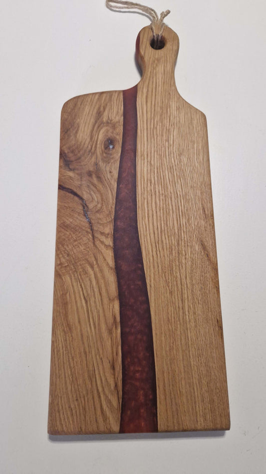 Handmade charcuterie board with oak and red epoxy design.
