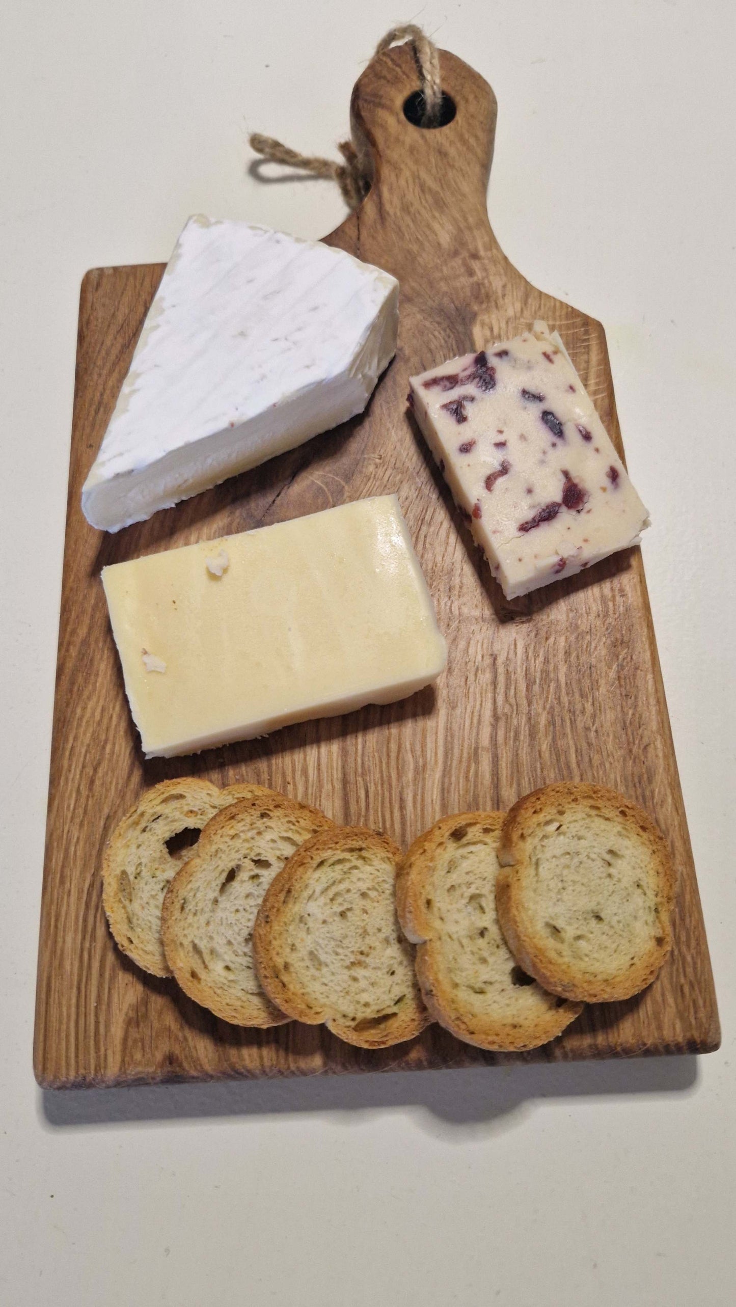 Handmade charcuterie board with assorted cheeses and bread slices.