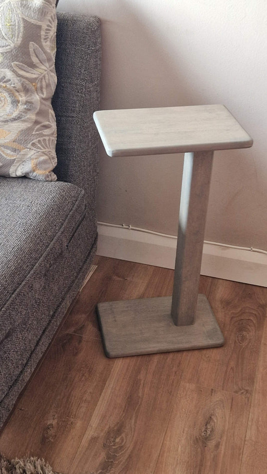 Handmade oak wooden couch table in grey, 21 cm x 18 cm, next to a sofa in a modern interior.