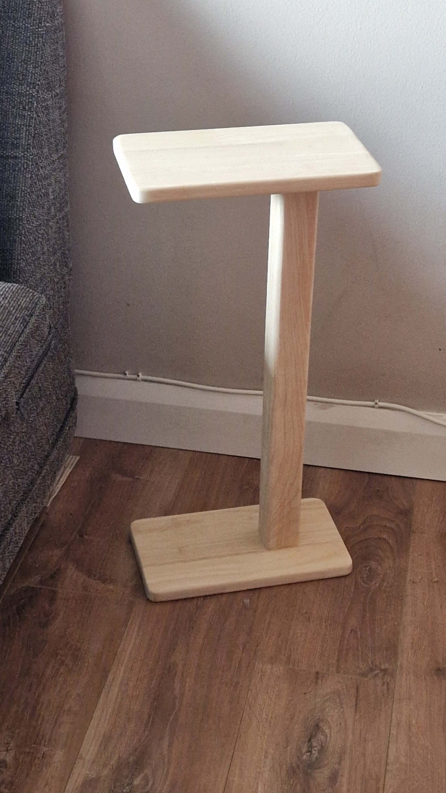 Handmade oak wooden couch table with sleek C-shape design on wooden floor.