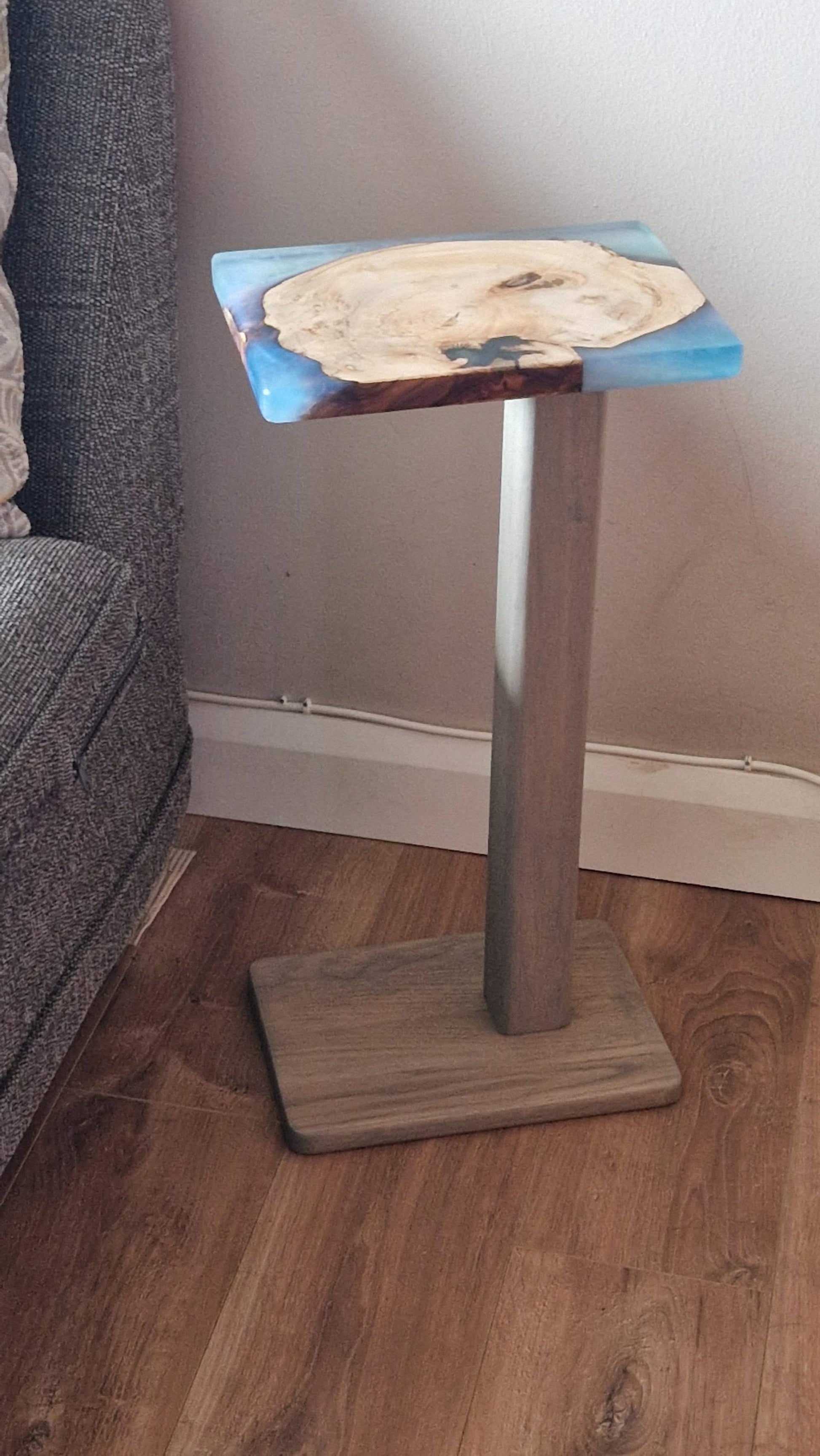 Handmade oak wooden couch table with epoxy finish, 30cm x 20 cm, placed beside a couch.