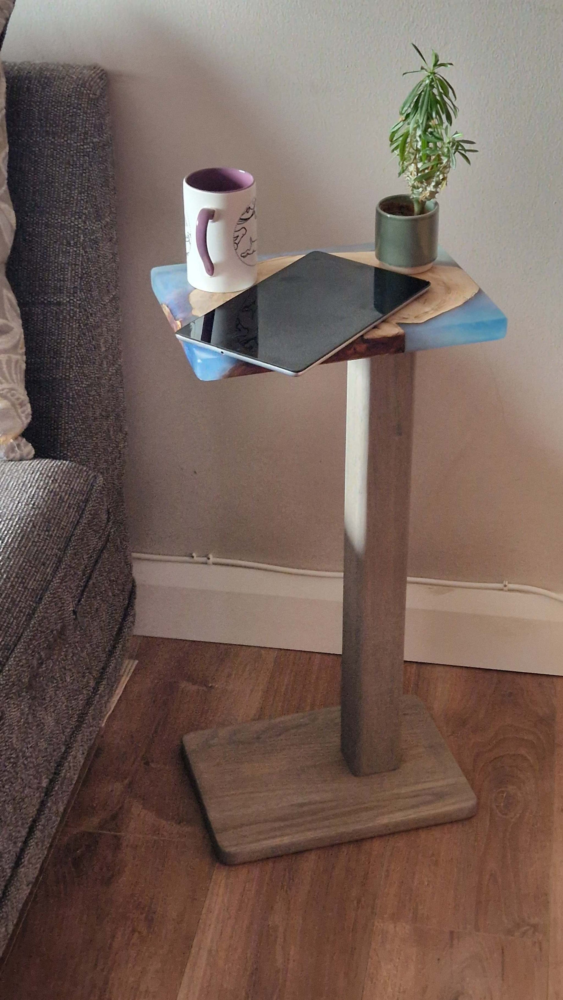 Handmade oak wooden couch table with epoxy finish, 30cm x 20cm, beside a couch with a mug and plant on top.