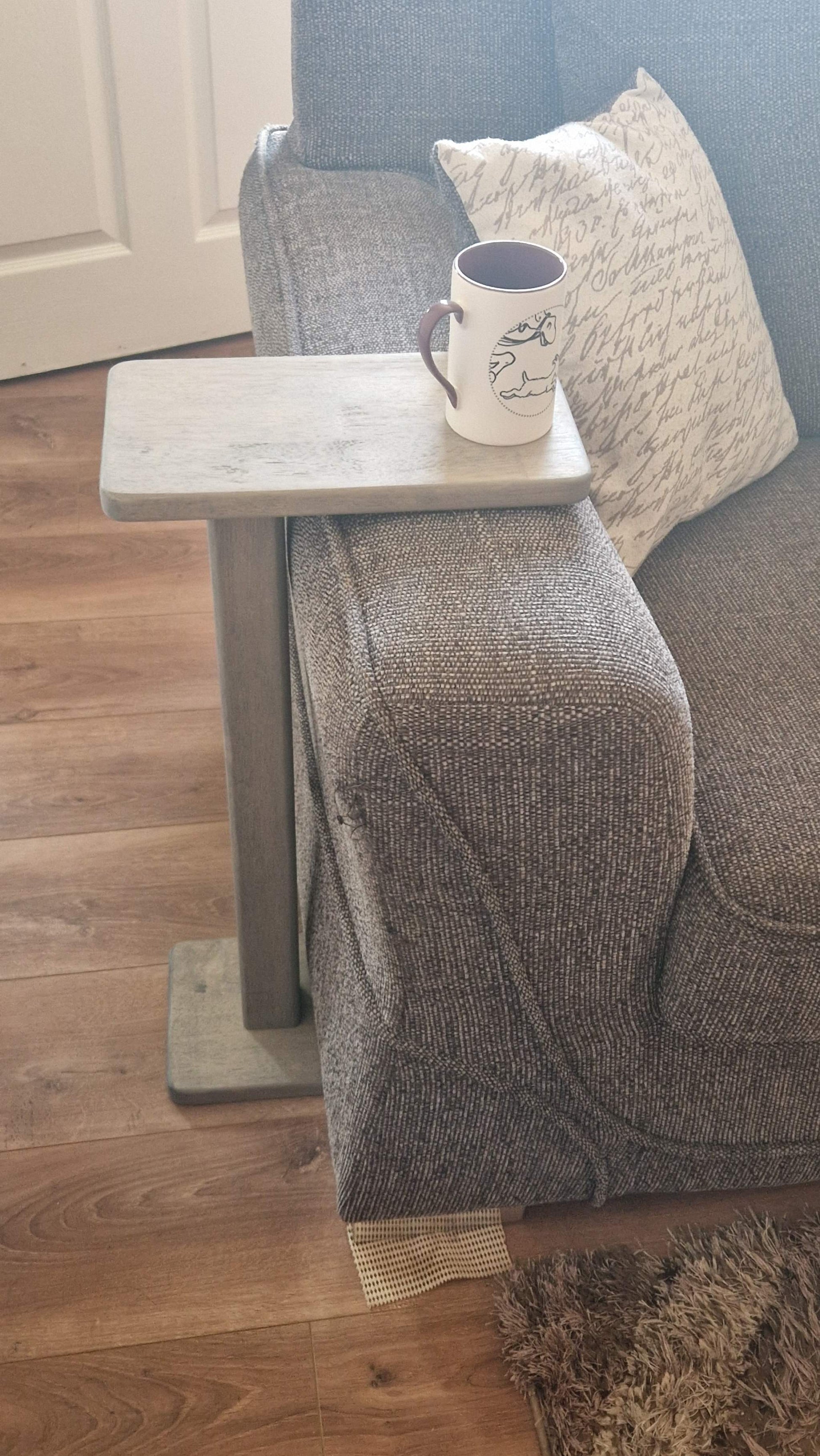 Handmade oak wooden couch table in grey, positioned by sofa with a mug placed on top.