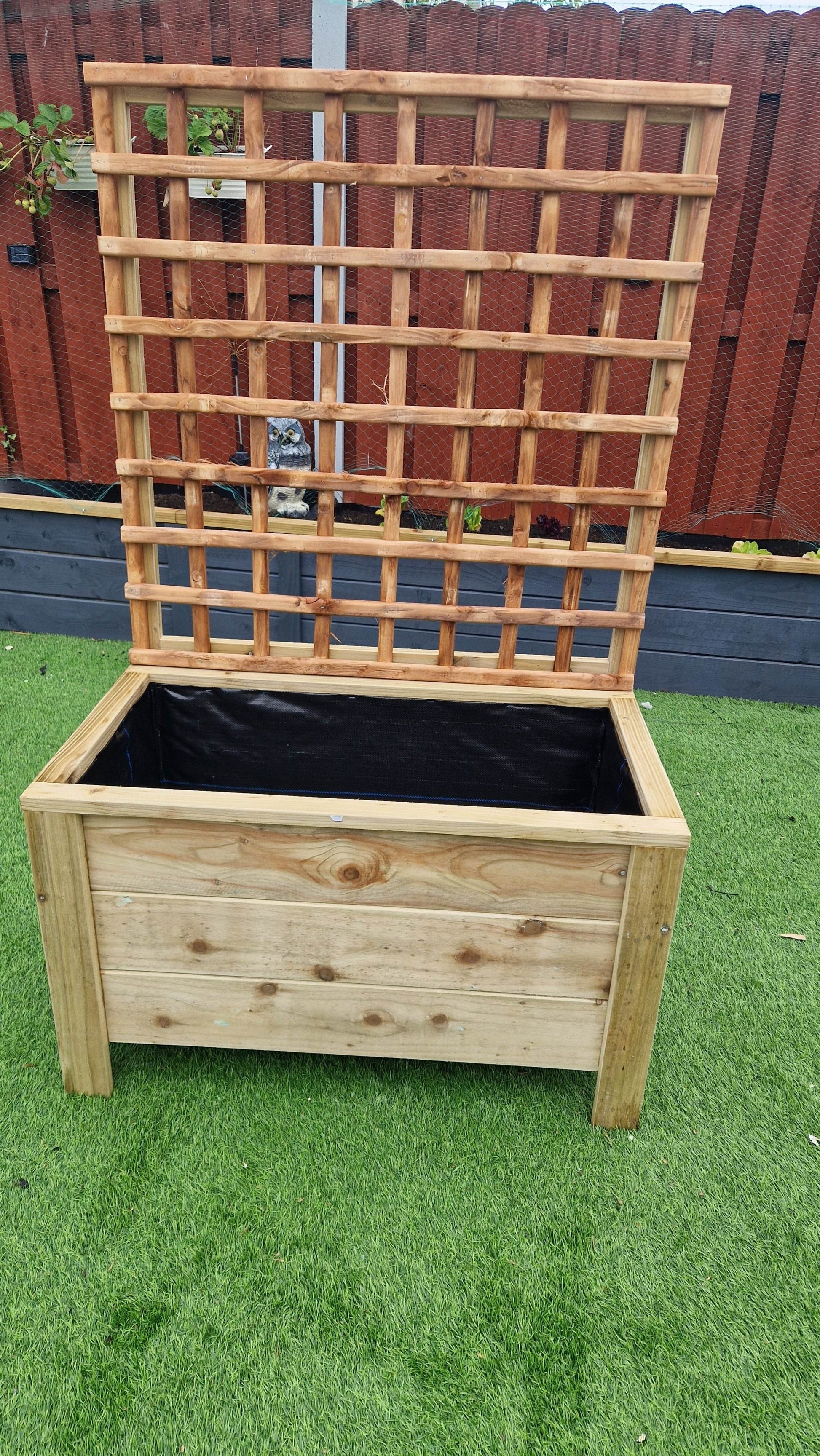 Handcrafted wooden planter with trellis on grass, ideal for climbing plants.
